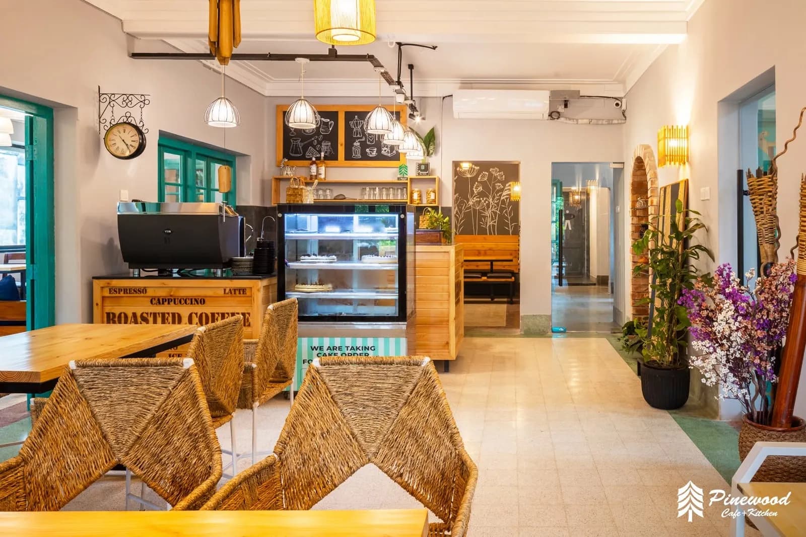 Coffee counter with an espresso machine, a cake display and woven chairs