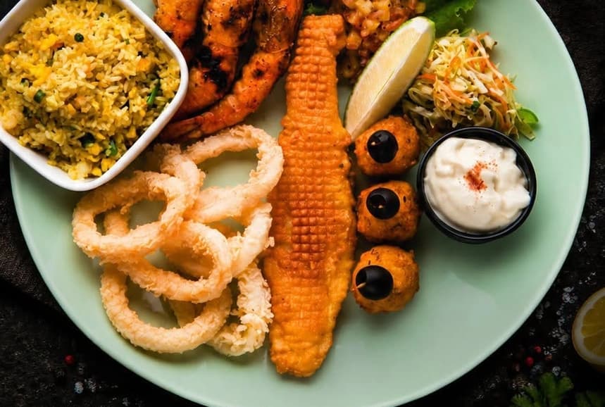Seafood Platter: yellow rice, grilled prawns, fried dory, fried calamari, fish balls, garlic mayo and salsa