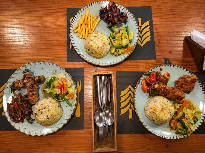 Three set-menu plates with fried rice on Pinewood placemats, seen from above