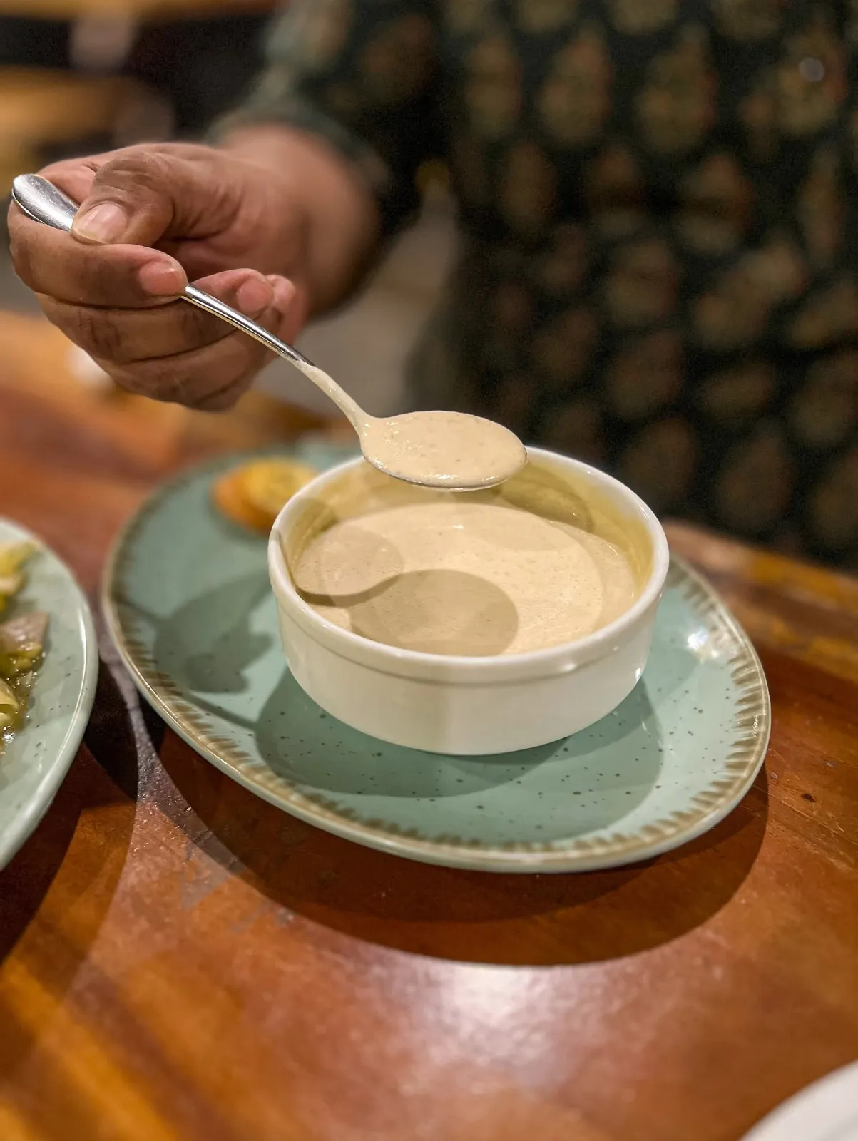 A bowl of cream soup with garlic bread